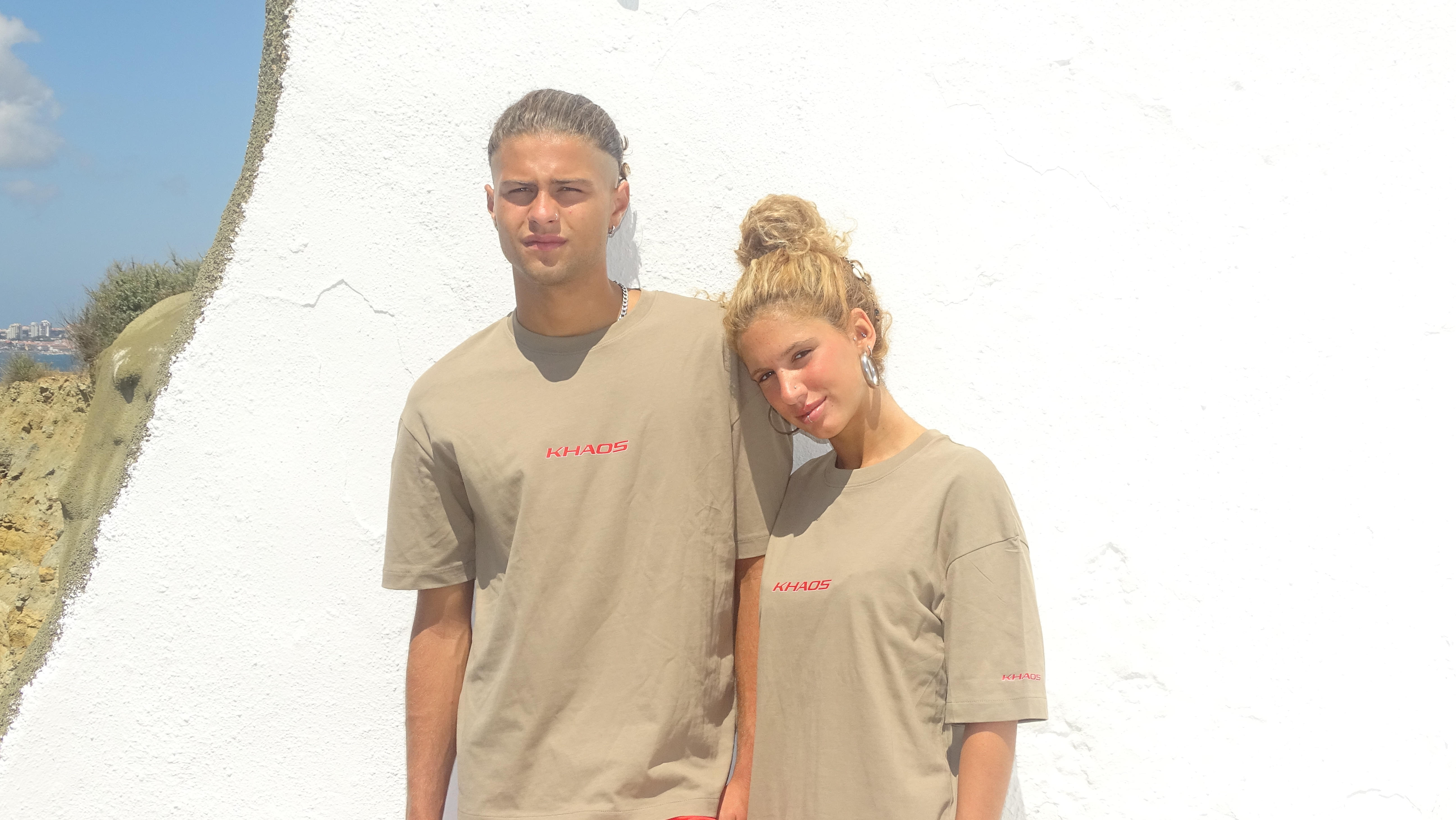 Casal a usar a KHAOS Tee do Drop 001 junto ao mar